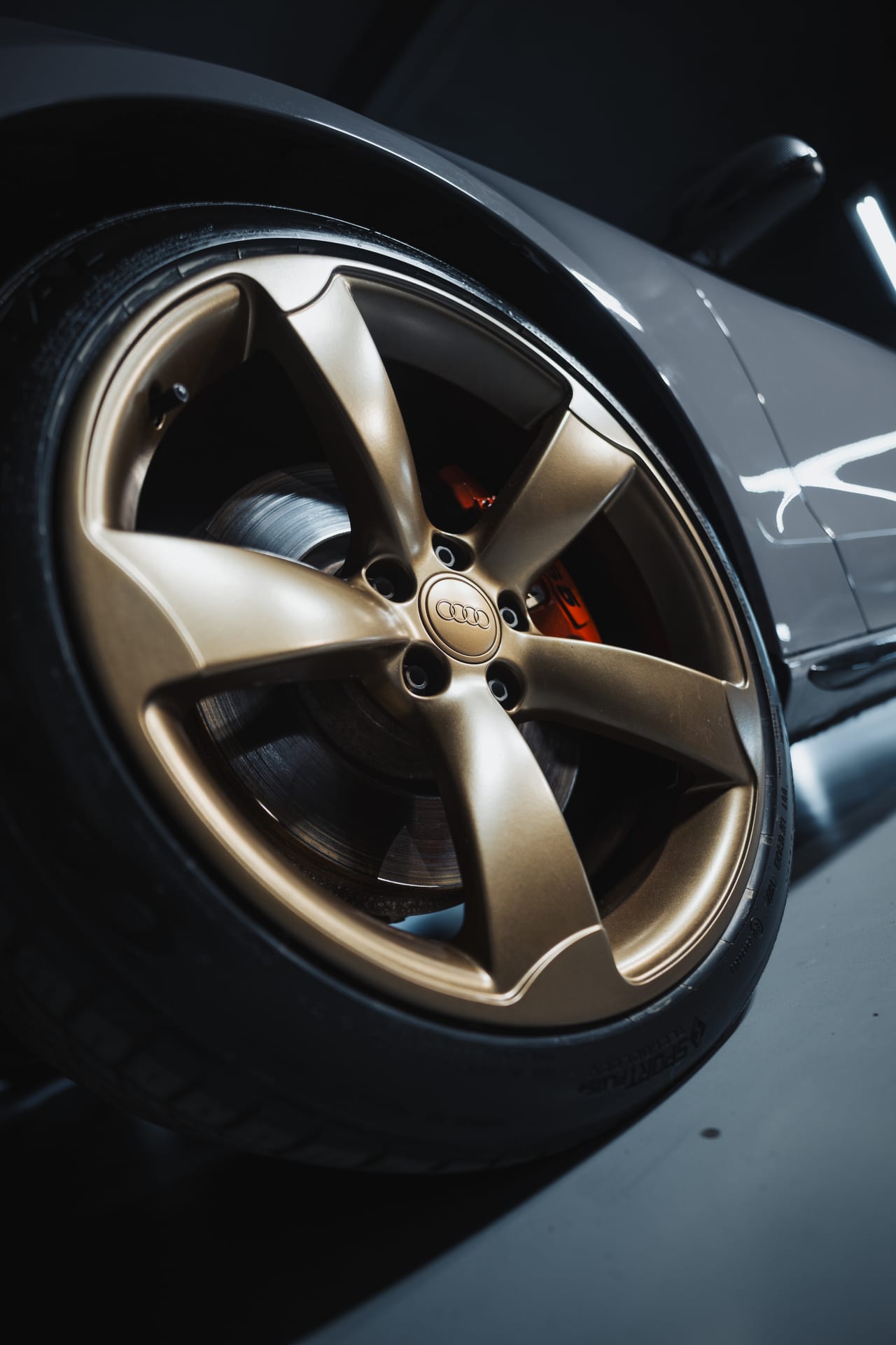 Bronze Audi wheel close-up with red brake calipers